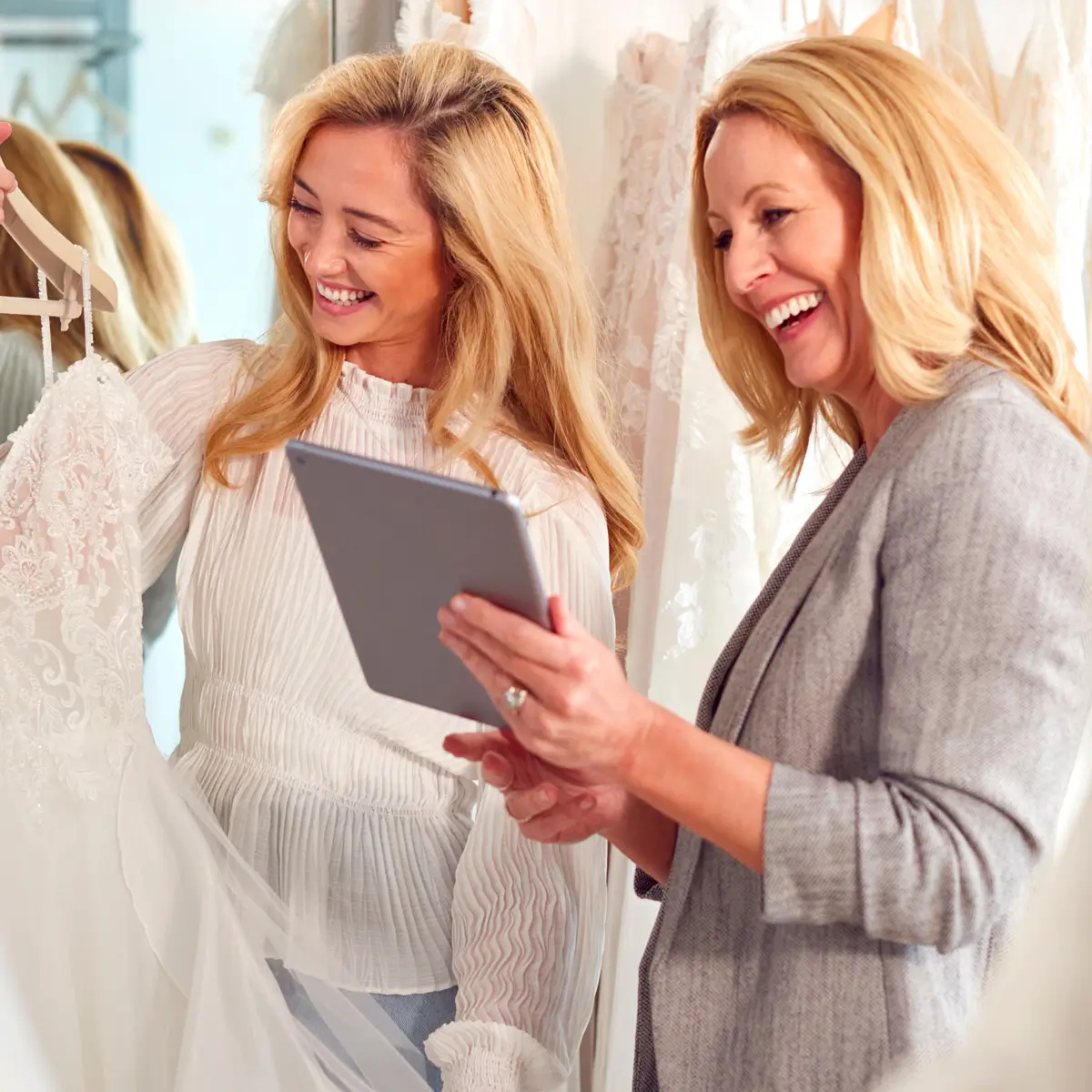 Bride and bridal store owner looking at dresses